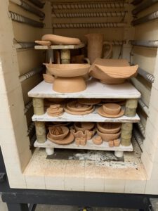 Foto des geöffneten Brennofens mit verschiedenen Ebenen bestückt mit geschrühter Keramik.